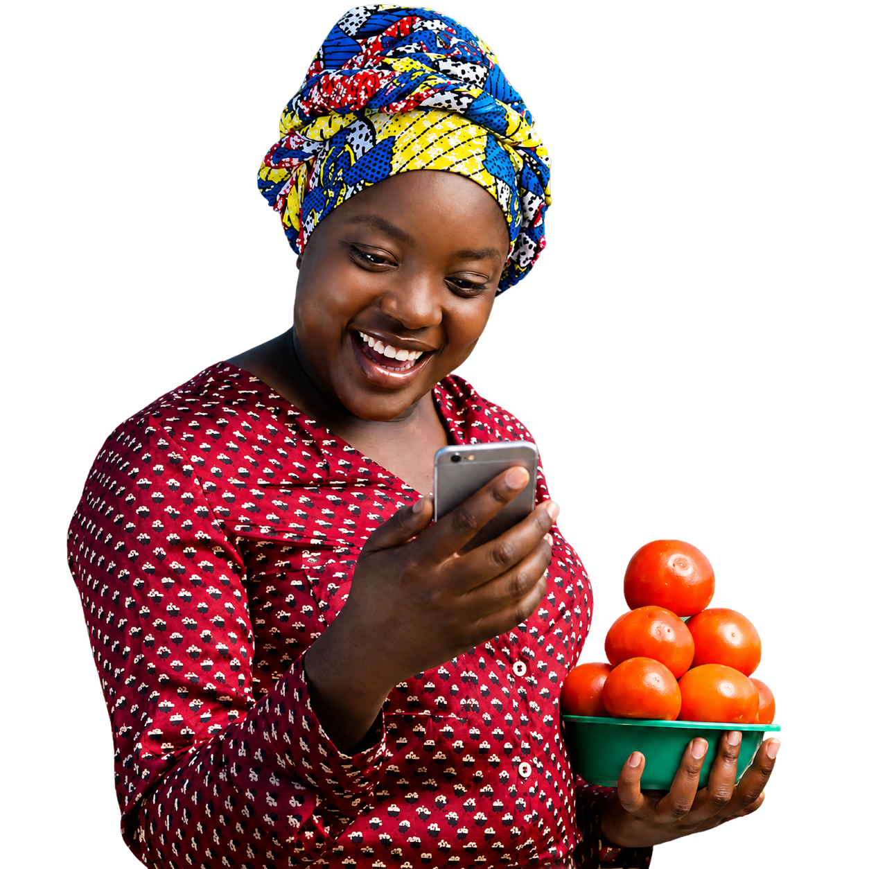 A woman smiling at her phone, holding a bowl of oranges